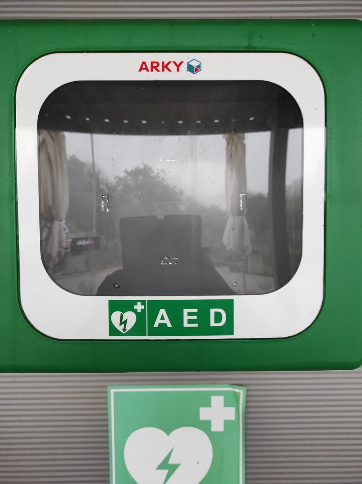 Prázdná schránka na defibrilátor AED na budově sportovní haly